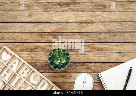 Set of wooden letters of the English alphabet and a notepad on a wooden background, top view. Stock Photo