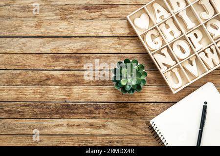 Set of wooden letters of the English alphabet and a notepad on a wooden background, top view. Stock Photo