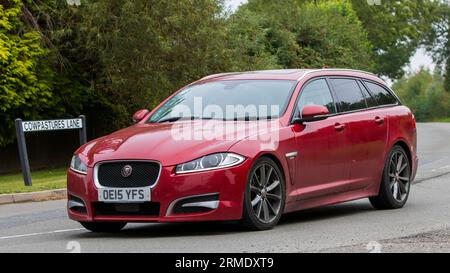 Whittlebury,Northants,UK -Aug 26th 2023: 2015 red Jaguar XF r sport car travelling on an English country road Stock Photo