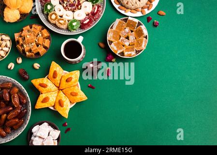 Middle Eastern Sweets, Turkish Delights and Black Coffee on green background, copy space. Arab dessert assortment, rahat lokum, halva, sherber, pisman Stock Photo