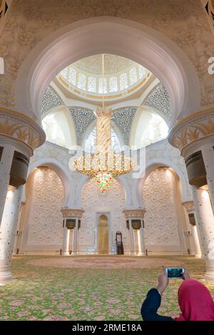 Woman tourist taking photo in central prayer hall, Sheikh Zayed Mosque Stock Photo