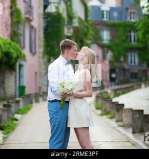 Bride and groom kissing on a street of Montmartre in Paris Stock Photo