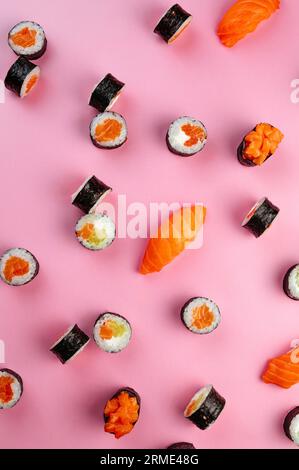 classic japanese sushi rolls randomly placed on a pink backgroun Stock Photo