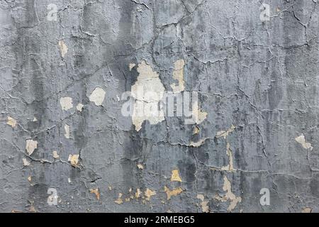 Scratched uneven wall painted surface with damaged gray plaster as background front view close up Stock Photo
