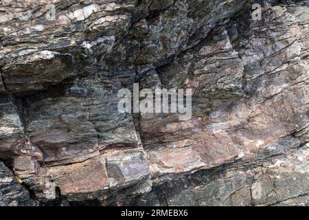 Bands of red laterite rock (iron from vegetation)in basaltic lava flow, Murlough Bay, Northern Ireland, UK Stock Photo