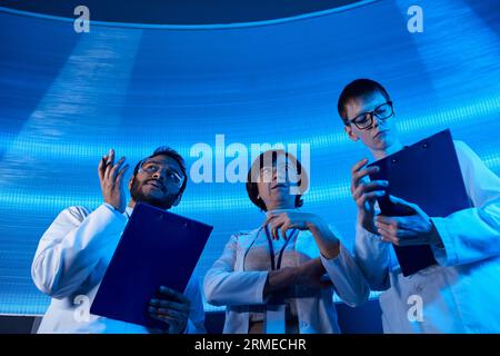 indian scientist pointing with hands near colleagues in science center, future-oriented Stock Photo
