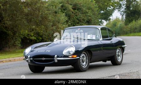 Whittlebury,Northants,UK -Aug 26th 2023: 1963 e-type Jaguar sports car travelling on an English country road Stock Photo