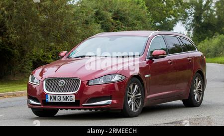Whittlebury,Northants,UK -Aug 26th 2023: 2013 red Jaguar XF luxury sportbrake V6 diesel engine car travelling on an English country road Stock Photo