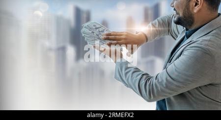 Portrait of happy young indian businessman holding cash money in his hands Stock Photo