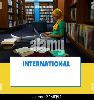 Composite of international school library month text and biracial woman in hijab using laptop Stock Photo