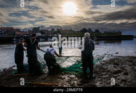 Traditional salmon fishermen fishing at the mouth of the River Tweed, Berwick upon Tweed, Northumberland, England, UK Stock Photo