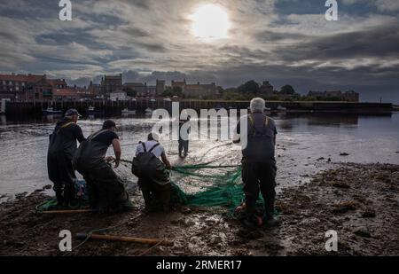 Traditional salmon fishermen fishing at the mouth of the River Tweed, Berwick upon Tweed, Northumberland, England, UK Stock Photo