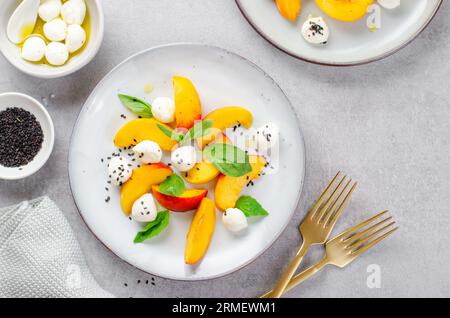 Grilled Peach Salad with Mozzarella Pearls on Bright Background Stock Photo