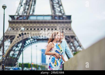 Happy romantic couple near the Eiffel tower in Paris, Tourists enjoying their vacation to France Stock Photo