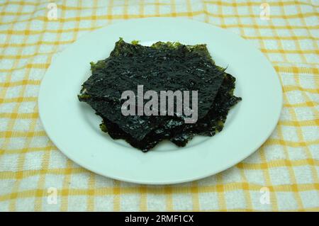 Crispy Dried seaweed on a white plate Stock Photo