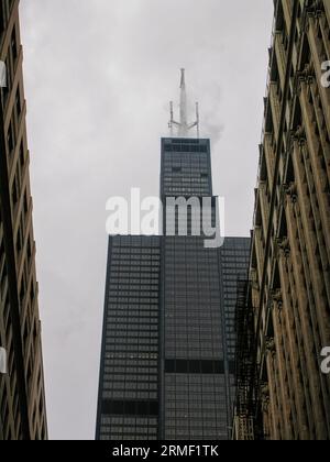 Willis Tower in Chicago, Illinois with mist surrounding its antennas. The mist creates a mysterious and ethereal atmosphere. Stock Photo