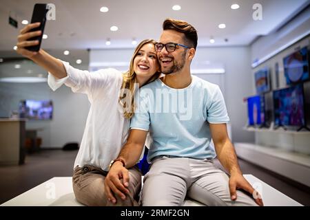 Couple is making selfie using a smart phone. Digital device, artificial intelligence concept. Stock Photo