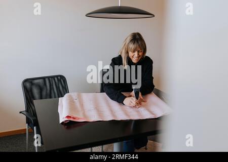 Smiling female engineer working on plans Stock Photo