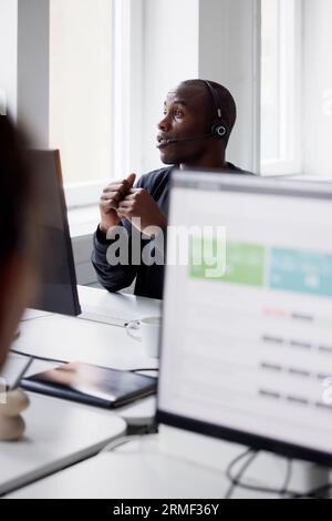 Mature businessman using headset and while sitting in office Stock Photo
