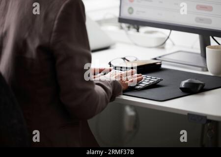 Mid section of woman in office using desktop PC Stock Photo