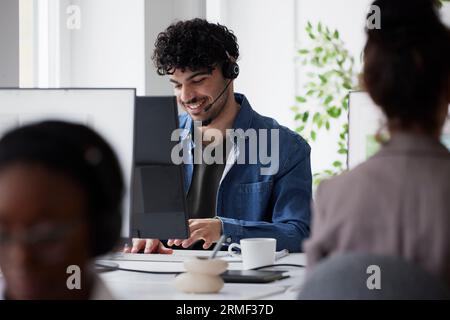 Young man using headset while sitting in office Stock Photo