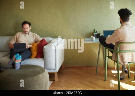 Homosexual couple relaxing in living room Stock Photo