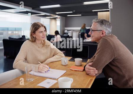 Two professionals working together in office cafeteria Stock Photo