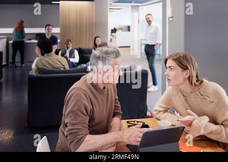 Two professionals working together in office cafeteria Stock Photo