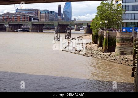 View of Thames shore at low tide and Southwark Bridge from area around Thames path Oystergate Walk near London Bridge London England UK  KATHY DEWITT Stock Photo