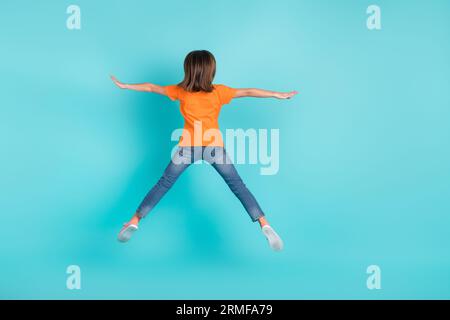 Back rear view photo of funky girl wear trendy clothes jump up fly air rejoice seasonal sale discount isolated on cyan color background Stock Photo