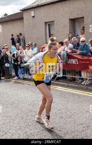 Competitors take part in the Scottish Coal Carrying Championships through the streets of Kelty in Fife Stock Photo