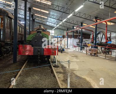 Bressingham, Norfolk, UK – August 21 2023. The inside of a large shed full of steam trains, boats, machines, spares and memorabilia Stock Photo