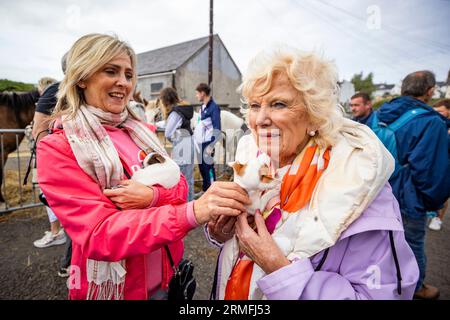 Donna Spears with her mother Anne Watson from Lisburn hold two Jack Chi (Jack Russell Chihuahua mix) dogs for sale during the Ould Lammas Fair - Ireland's oldest traditional fair - on Bank Holiday Monday in Ballycastle, Northern Ireland. Picture date: Monday August 28, 2023. Stock Photo