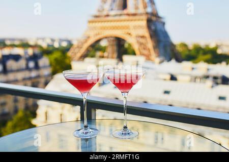 Two Cosmopolitan cocktails in traditional martini glasses on a glass table with view to the Eiffel tower, Paris, France Stock Photo