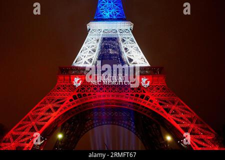 PARIS - NOVEMBER 16: Eiffel tower illuminated with colors of the French national flag on the day of mourning on November 16, 2015 in Paris Stock Photo