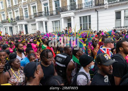 Notting Hill, London, UK. 28th Aug, 2023. Europe’s largest street festival is taking place in the streets of Notting Hill. Jamaican themed exotic dancers and musical groups are parading through the streets, with food and street entertainment around the area adding to the event. The Grand Parade takes place on Bank Holiday Monday as the culmination of the three-day festival, which began in 1966. Revellers packing the street, passing expensive properties in Kensington Stock Photo