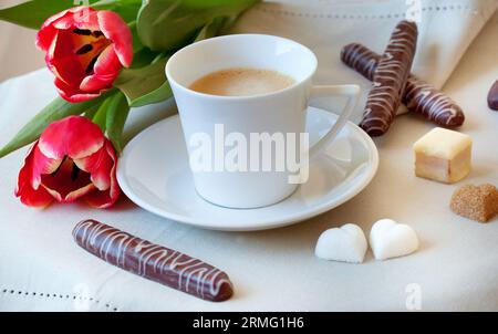 Morning coffee with cookies, heart-shaped pieces of sugar and flowers Stock Photo