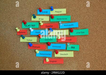 Different language names on colorful paper notes pinned to cork board Stock Photo