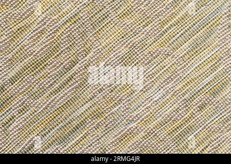 Multicolored woven rug with embossed pattern, which is canvas with white base and vertical cotton rows of beige color. Close up of textile background Stock Photo