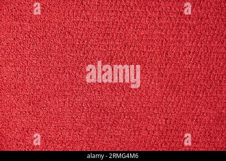 Dark red natural plush terry cloth, textured fabric macro background. Close up of saturated red velvet rug surface or upholstery fabric texture. Conce Stock Photo