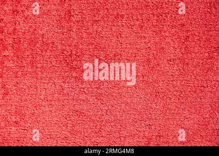 Surface of light red plush material or upholstery fabric texture. Close up of saturated red velvet carpet abstract background. Concept of textures and Stock Photo