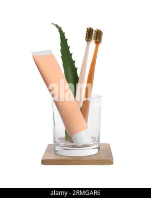 Tube of toothpaste, brushes and aloe vera leaf in glass on white background Stock Photo