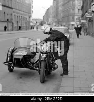 In the 1960s. A woman seen dressed in the typical motorcycle drivers outfit and helmet at her motorcycle with a sidecar for passenger. Sweden 1967 Stock Photo