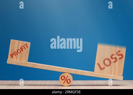 Increasing losses in the stock market. Loss and profit on the scales on a blue background. Loss of investment in stock exchange, bear market and Stock Photo