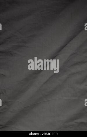Close-up of a wrinkled and gray cotton cloth or textile. Abstract high resolution full frame textured background in black and white, copy space. Stock Photo