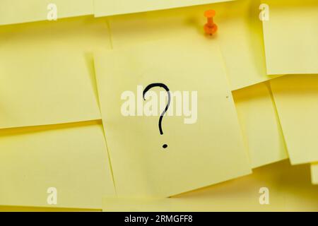 A stack of yellow sticky notes with question marks on them Stock Photo