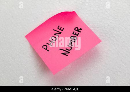 A close-up of a sticky note with a phone number written on it Stock Photo