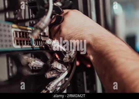 Close up of technician setting up network in server room  Stock Photo