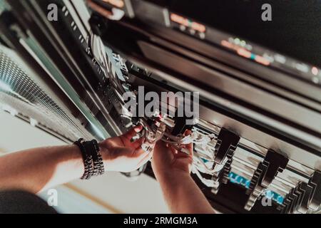Close up of technician setting up network in server room  Stock Photo
