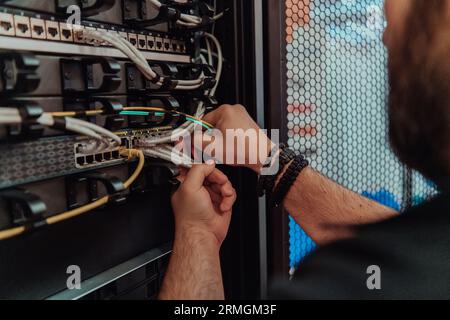 Close up of technician setting up network in server room  Stock Photo